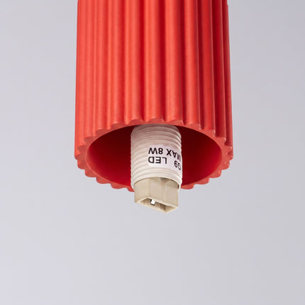 Plafonnier Halo rouge vif IP44 sur fond coloré, vue de trois quarts