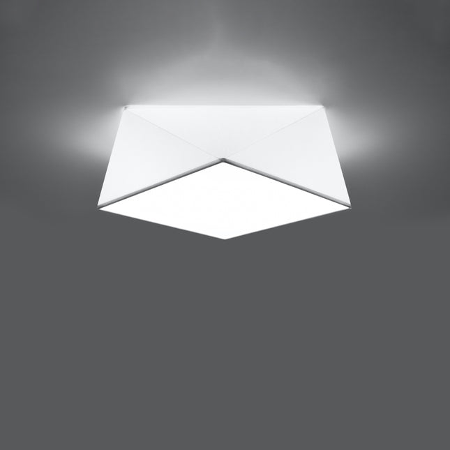 Plafonnier géométrique Hexa blanc allumé au plafond, lumière douce diffusée par le panneau carré central