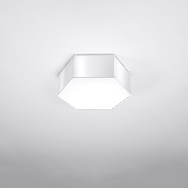 Plafonnier Hexagonal Pure 11 blanc allumé, lumière chaude diffusée par le hublot blanc.