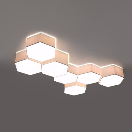 Plafonniers Hexagonal Pure assemblés au-dessus d'un meuble TV, composition allumée diffusant une lumière chaude.
