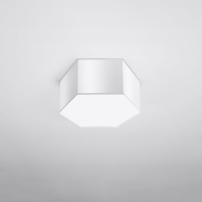Plafonnier Hexagonal Pure 15 blanc allumé, lumière chaude diffusée par le hublot blanc.