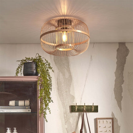 Hokkaido ceiling light in braided natural bamboo lit above a bookcase in a Japandi living room