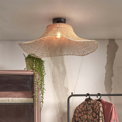 Plafonnier Ibiza Wavy en bambou tressé suspendu au plafond d'un dressing, ambiance bohème chaleureuse