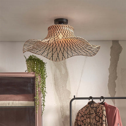 Plafonnier Ibiza Wavy en bambou tressé naturel et noir, abat-jour ondulé suspendu au plafond d'une chambre