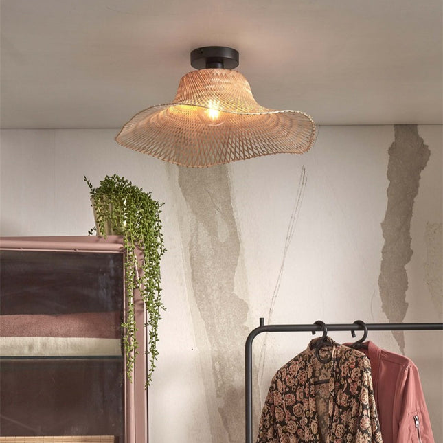 Plafonnier bambou tressé Ibiza Wavy éclairant un dressing bohème avec plantes vertes