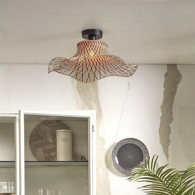 Plafonnier Ibiza Wavy en bambou tressé noir et naturel, abat-jour ondulé installé au plafond d'un salon