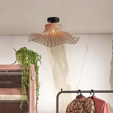 Plafonnier Ibiza Wavy en bambou tressé au-dessus d'un dressing avec plante suspendue