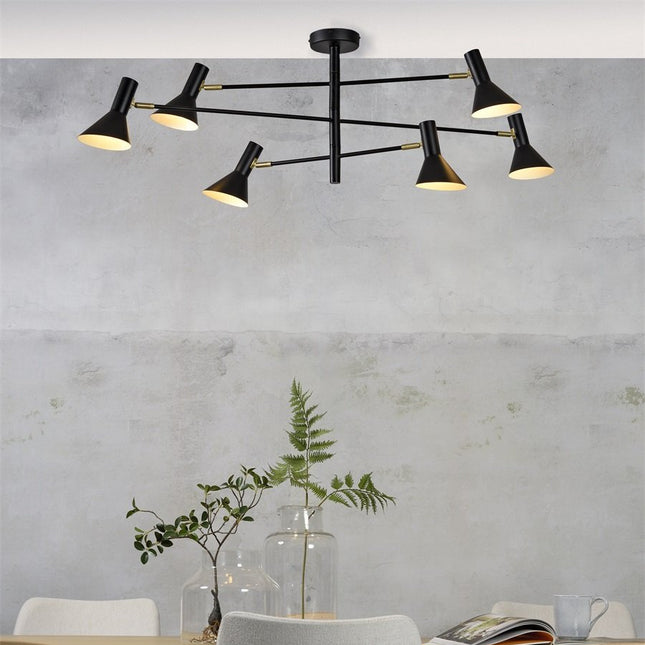 Izmir ceiling light black and gold hanging on the ceiling of a dining room, with top of a table in wood