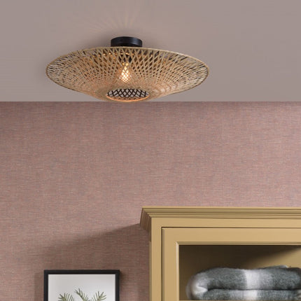 Plafonnier Kalimantan en bambou tressé installé au plafond d'un salon, diffusant une lumière douce sur un mur rose