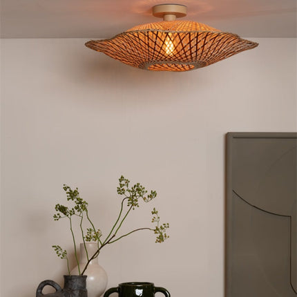 Plafonnier Madura allumé diffusant une lumière chaude à travers le tressage en bambou