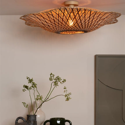 Vue en angle du plafonnier Madura en bambou tressé diffusant une lumière chaleureuse