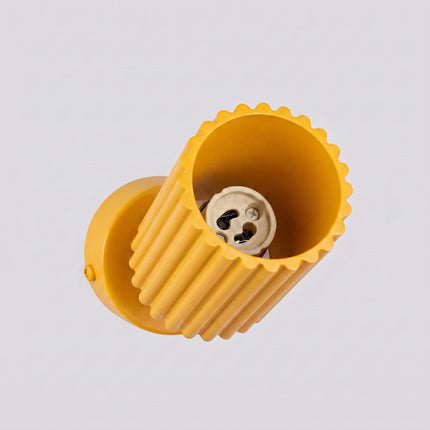 Plafonnier Oslo 1 spot orientable jaune ambré sur fond coloré, vue de trois quarts