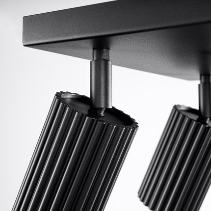 Plafonnier Oslo 4 noir allumé, diffusion de la lumière par les quatre spots orientables