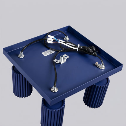 Plafonnier Oslo 4 spots orientables carré bleu outremer sur fond coloré, vue de trois quarts