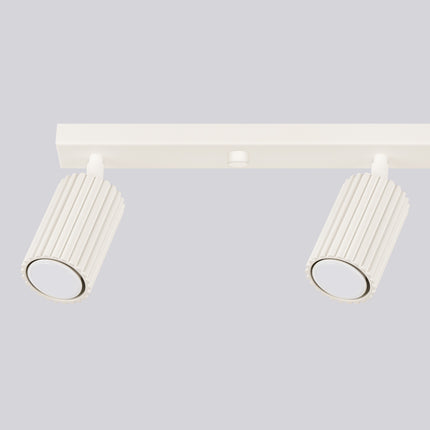 Gros plan sur deux spots allumés du plafonnier Oslo 4L beige, diffusant une lumière chaude et ciblée.