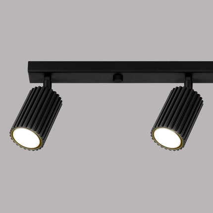 Détail d'un spot orientable du plafonnier Oslo 4L noir, finition cannelée en aluminium.