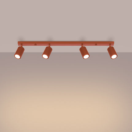 Vue en angle du plafonnier Oslo 4 lumières rouge ocre, spots cannelés en aluminium dans une ambiance chaleureuse.