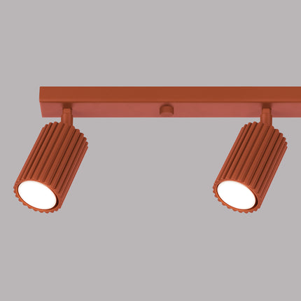Détail d'un spot orientable du plafonnier Oslo 4L rouge ocre, finition cannelée en aluminium.