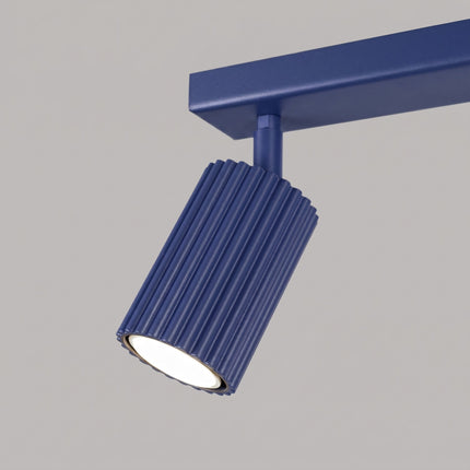 Plafonnier Oslo barre 2 spots orientables 30 cm bleu outremer sur fond coloré, vue de trois quarts