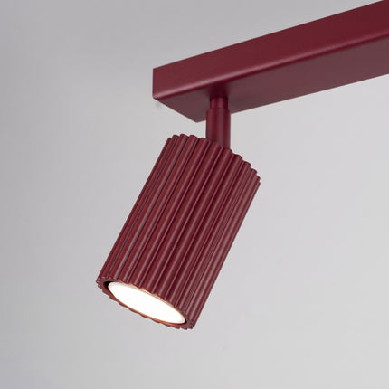 Plafonnier Oslo barre 2 spots orientables 30 cm bordeaux sur fond coloré, vue de trois quarts
