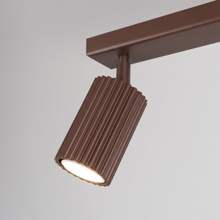 Plafonnier Oslo barre 2 spots orientables 30 cm brun chocolat sur fond coloré, vue de trois quarts