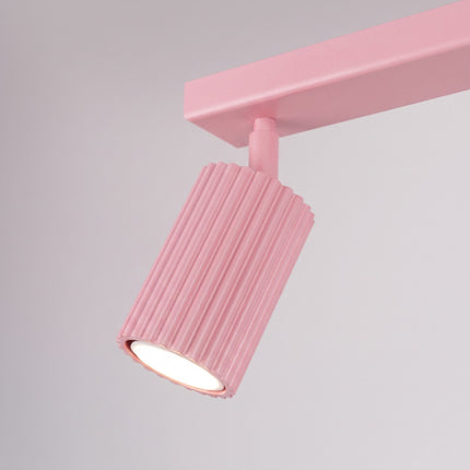 Plafonnier Oslo barre 2 spots orientables 30 cm rose poudré sur fond coloré, vue de trois quarts