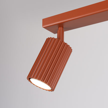 Plafonnier Oslo barre 2 spots orientables 30 cm rouge ocre, vue sur fond coloré