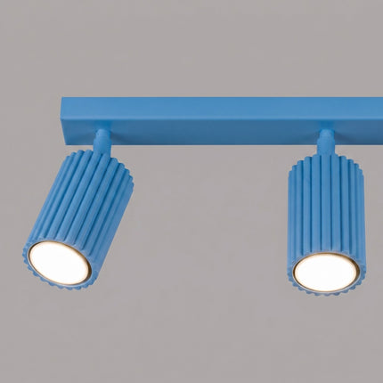 Plafonnier Oslo barre 3 spots orientables 45 cm bleu ciel sur fond coloré, vue de trois quarts
