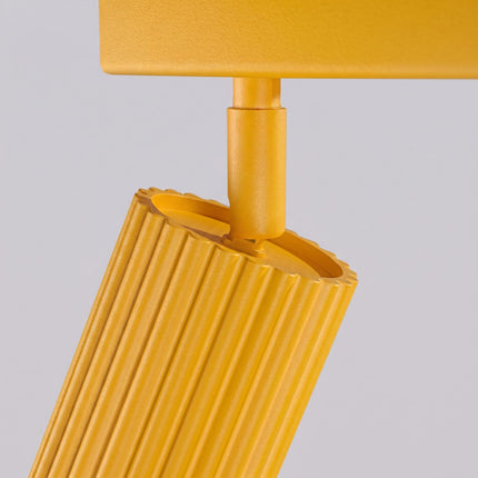 Plafonnier Oslo barre 3 spots orientables 45 cm jaune ambré sur fond coloré, vue de trois quarts