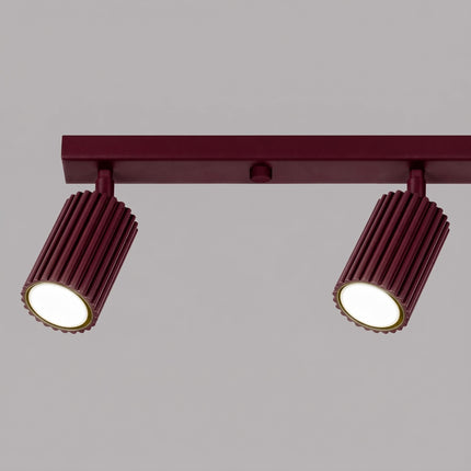 Plafonnier Oslo Barre 4 Spots Orientables 81 cm en Aluminium Bordeaux, vue sur fond coloré