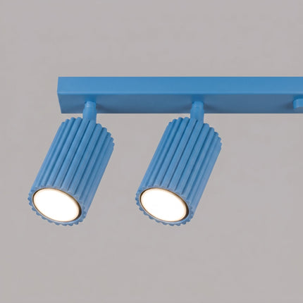 Plafonnier Oslo barre 6 spots orientables 117 cm bleu ciel sur fond coloré, vue de trois quarts