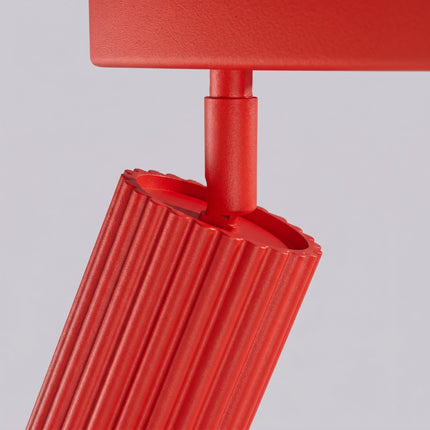 Plafonnier Oslo barre 6 spots orientables 117 cm rouge vif sur fond coloré, vue de trois quarts