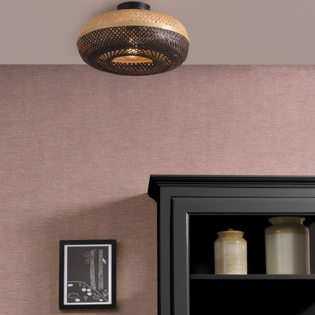 Plafonnier Palawan en bambou tressé noir et naturel installé au plafond d'un salon aux tons rosés
