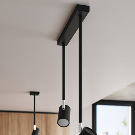 Plafonnier Précision Moderne 2 noir orienté vers un mur d'exposition dans une pièce au style industriel