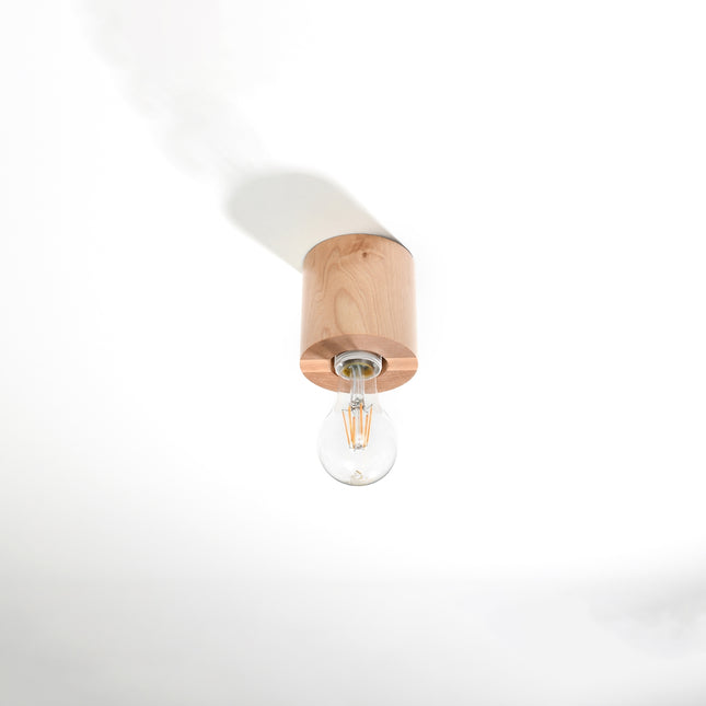 Plafonnier cylindre en bois naturel fixé au plafond blanc, ampoule filament E27 apparente orientée vers le bas.