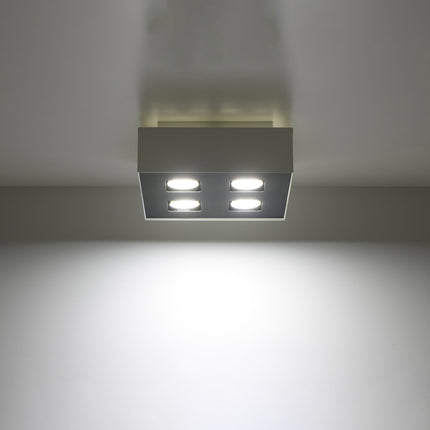 Plafonnier Quadruple Raffiné blanc projetant un faisceau de lumière vers le bas