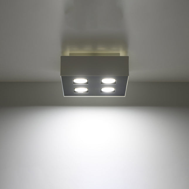 Plafonnier Quadruple Raffiné blanc projetant un faisceau de lumière vers le bas
