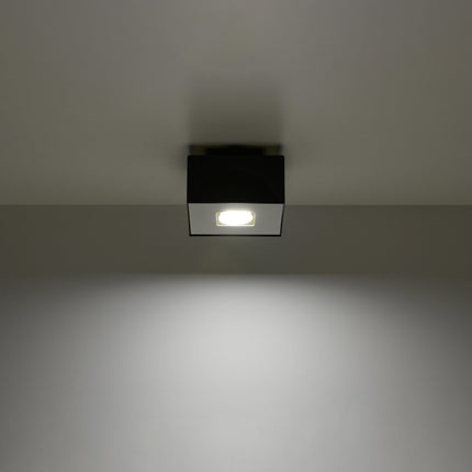 Plafonnier Raffiné noir projetant un faisceau de lumière vers le bas