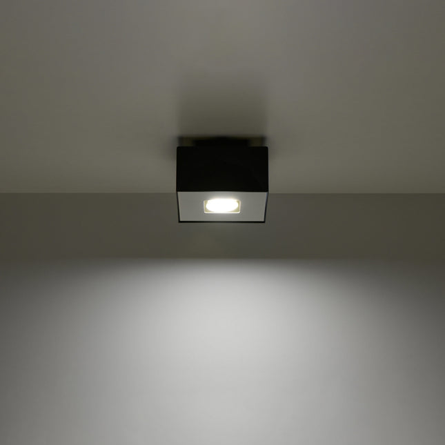 Plafonnier Raffiné noir projetant un faisceau de lumière vers le bas