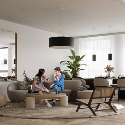 Plafonnier tissu noir dans un salon japandi au-dessus d'une table basse en pierre