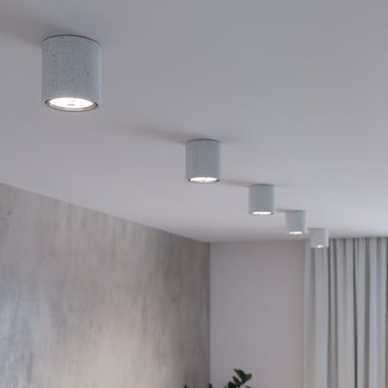 Détail de plafonniers Solide Chic en béton alignés au plafond