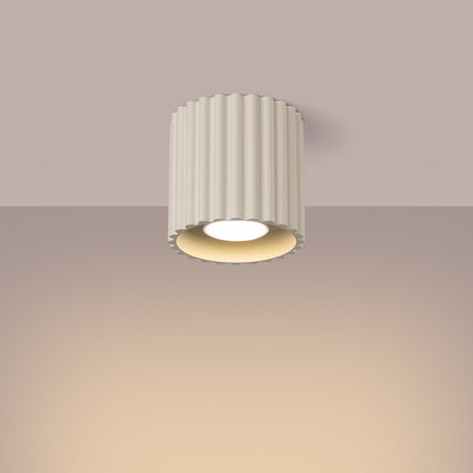 Plafonnier spot Aura beige allumé diffusant une lumière chaude au plafond