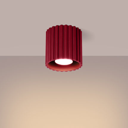 Plafonnier spot Aura bordeaux allumé diffusant une lumière chaude au plafond