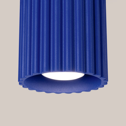 Détail du corps cannelé en aluminium bleu outremer du plafonnier Aura et de sa lumière