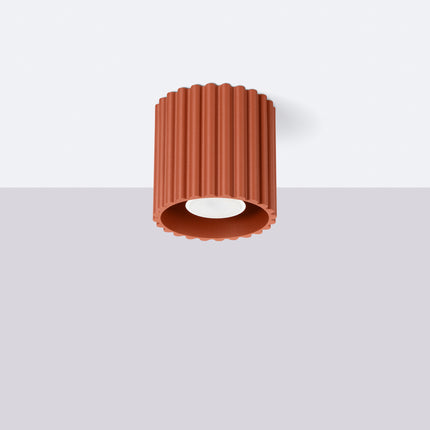 Spot Aura terracotta cannelé posé en saillie sous un plafond blanc dans un intérieur épuré