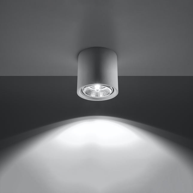 Plafonnier spot cylindrique blanc allumé projetant un faisceau de lumière ciblé