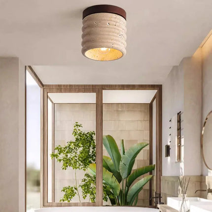 Plafón de travertino difundiendo una luz suave en un baño con plantas
