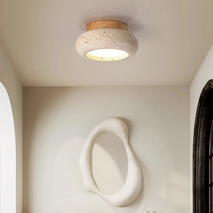 Plafonnier travertin et bois clair diffusant une lumière douce dans un couloir clair