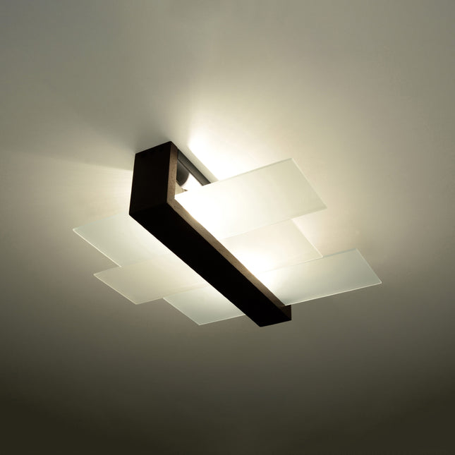 Plafonnier panneaux horizontal noir diffusant une lumière tamisée dans un salon