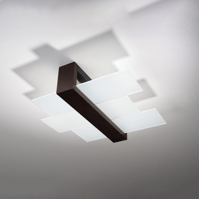 Plafonnier triple panneaux horizontal noir au-dessus d'une table de salle à manger